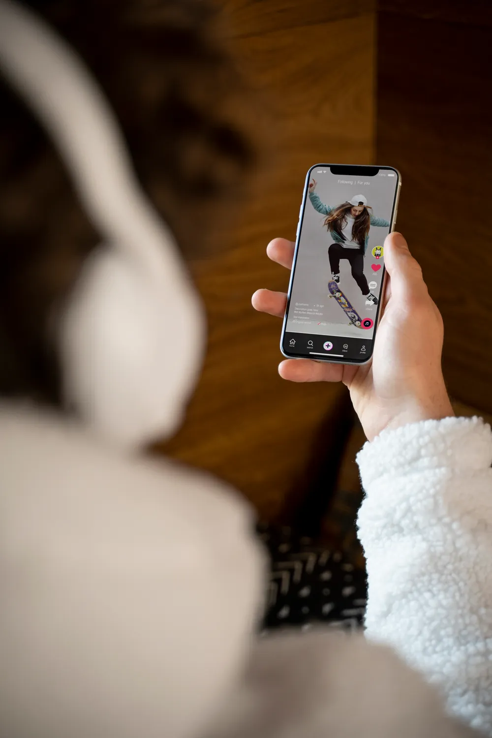 Mano sosteniendo un celular con un video de redes sociales en pantalla